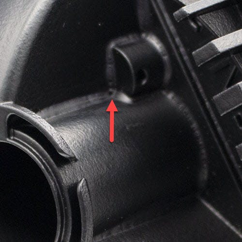 Close up photo of bridging defect on a plastic part